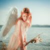 woman in pink dress holding white feather